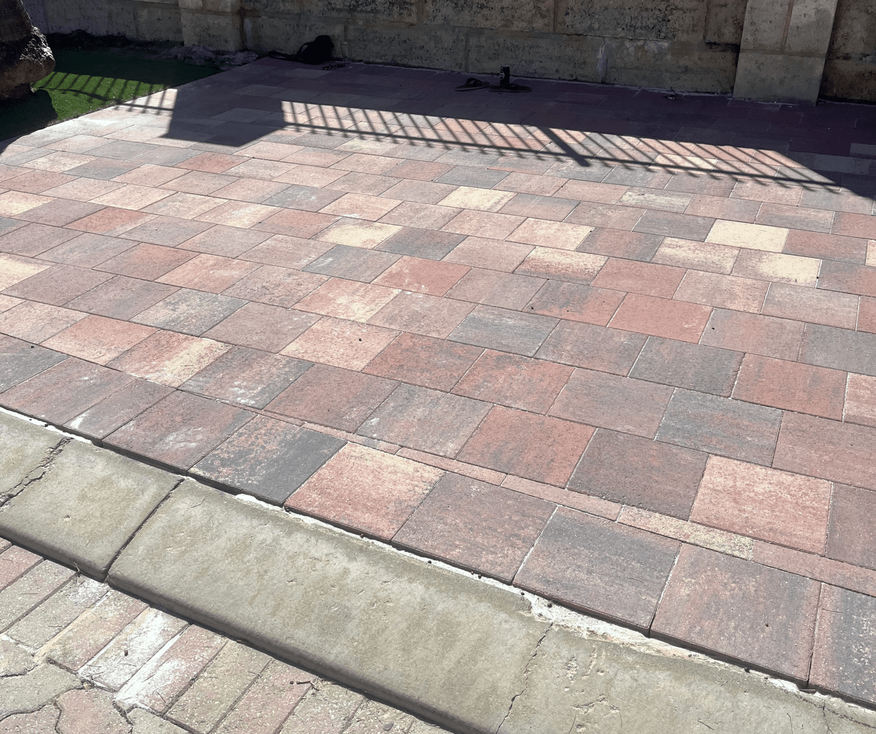 Red blend pavers laid across a driveway with a kerb edge