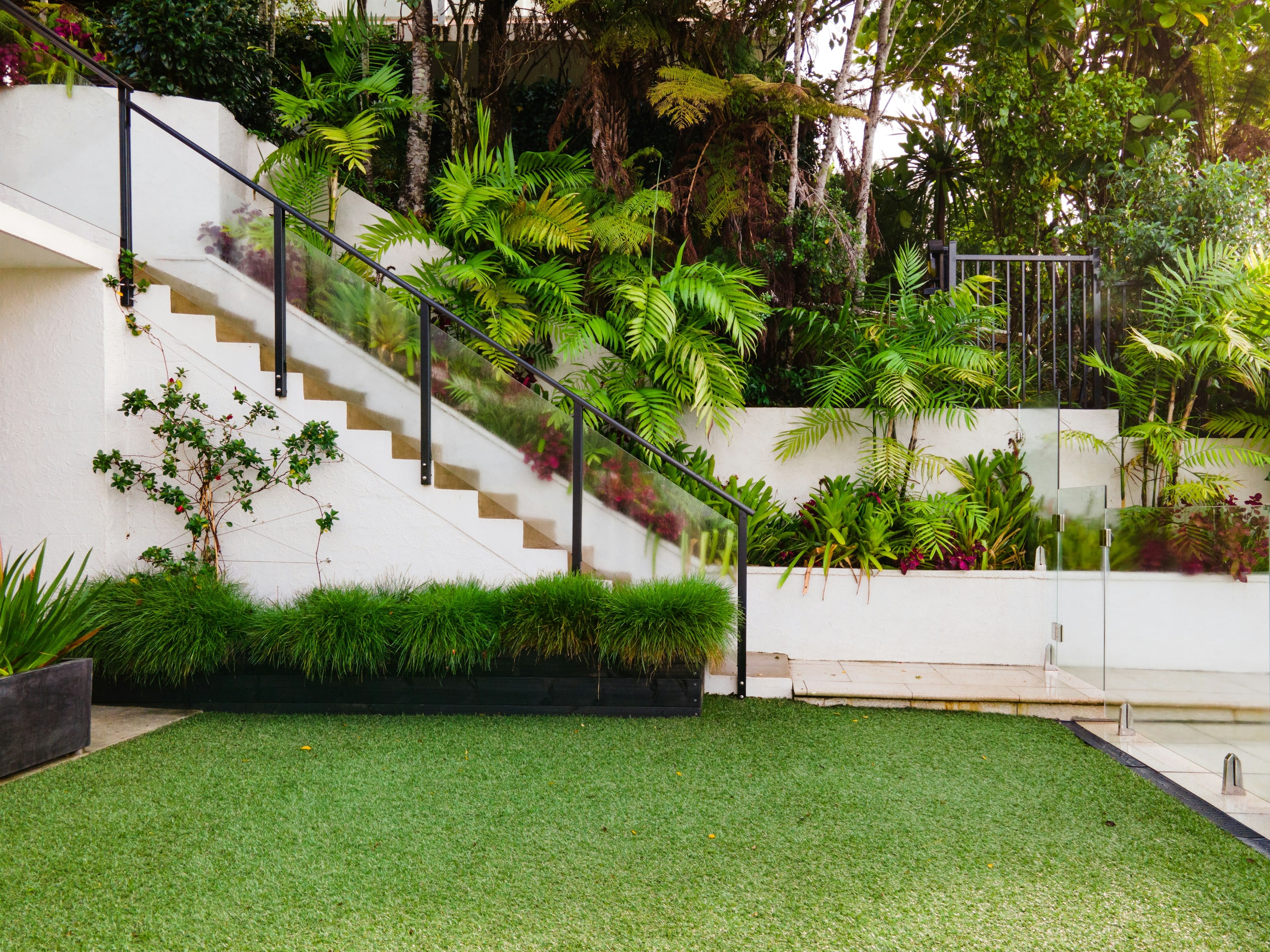 Rendered retaining walls and garden steps above a level green lawn