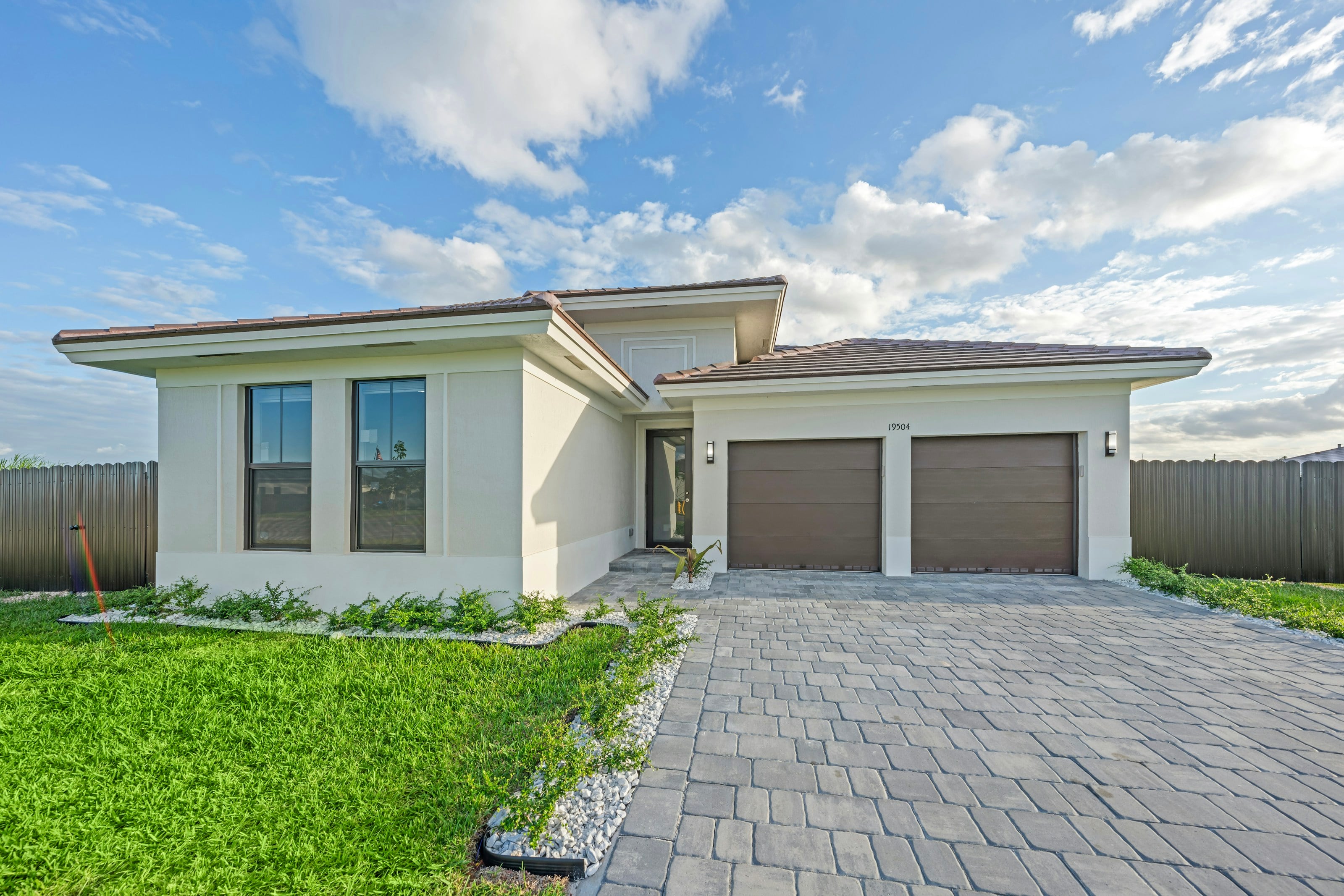 Modern single-storey home with a grey paved driveway leading to a double garage