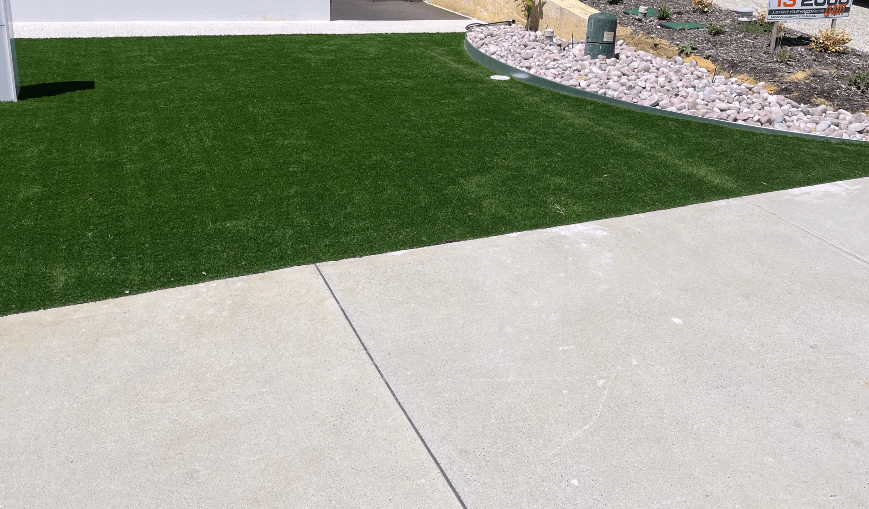 Artificial front lawn on a new build beside a concrete driveway